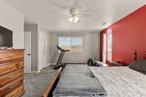 Bedroom with dark carpet and ceiling fan