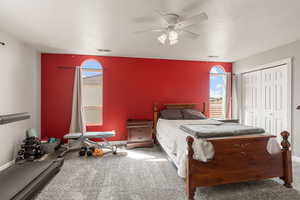 Carpeted bedroom with a closet and a ceiling fan