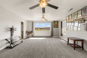 Family room with light colored carpet and a ceiling fan