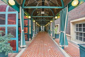 Hallway with lofted ceiling and brick flooring