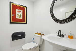Half bathroom featuring toilet and a sink