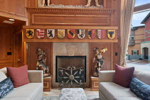 Living area with a tile fireplace, wood walls, and tile patterned flooring
