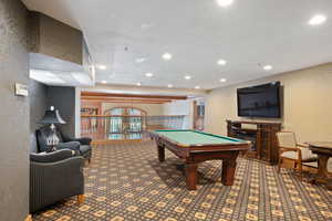 Playroom with recessed lighting, billiards table, and a textured wall
