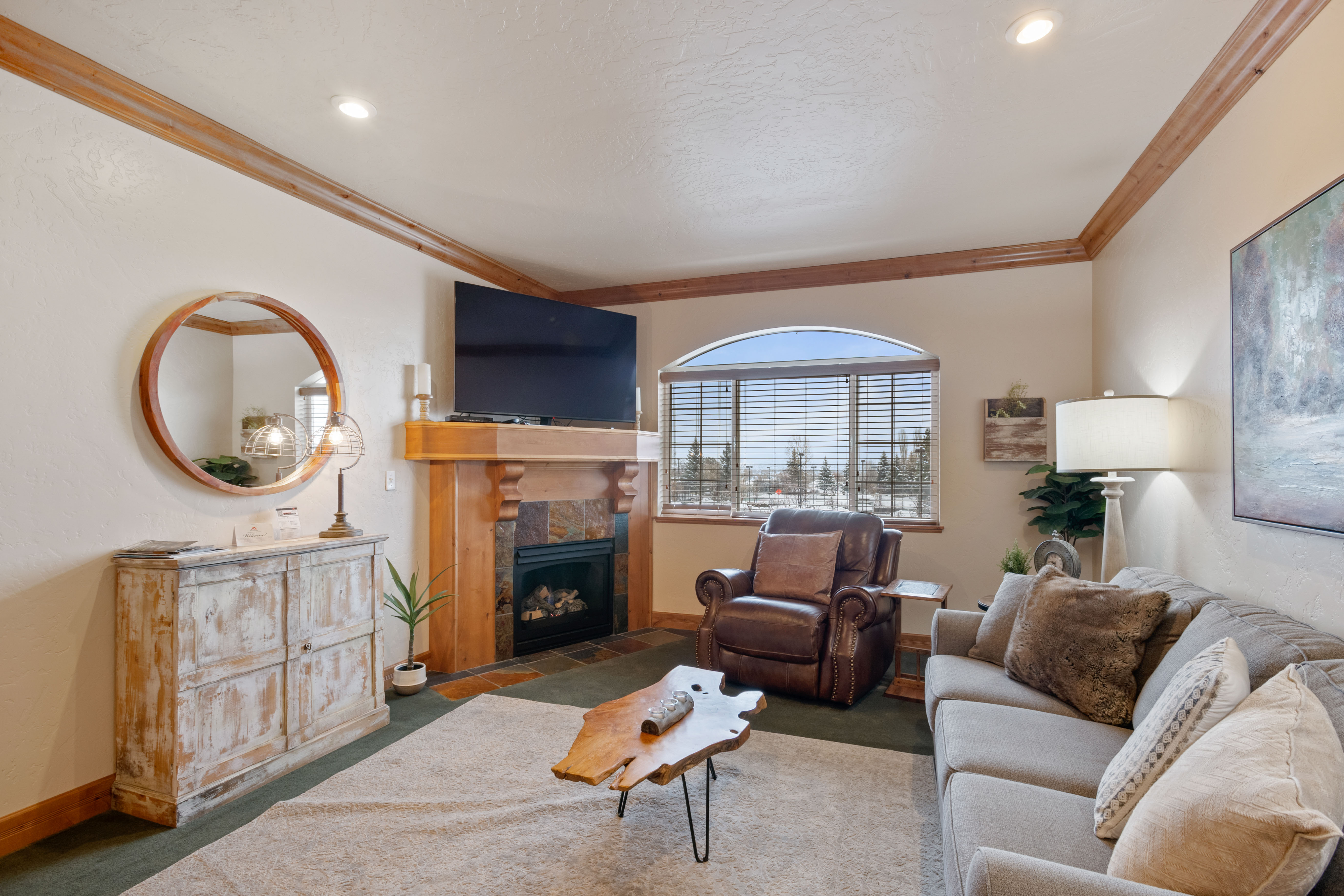 Living area with carpet, crown molding, and a fireplace with flush hearth