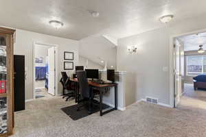 Home office featuring light carpet and ceiling fan