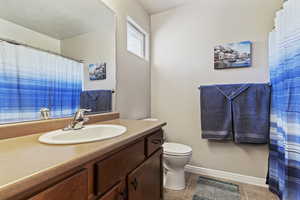 Full bath featuring vanity, a shower with curtain, and light tile patterned flooring