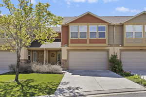 View of front of home with roof with shingles, a garage, concrete driveway, and stucco siding