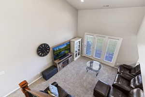 Living room with carpet flooring and a high ceiling