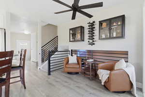 Living area featuring light wood finished floors and a ceiling fan
