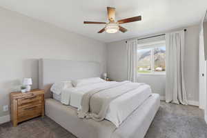 Bedroom featuring ceiling fan and carpet