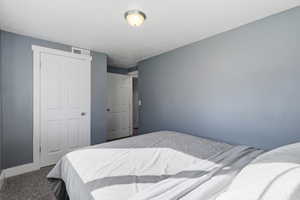 Carpeted bedroom with a closet and baseboards