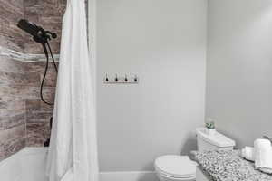 Full bathroom with shower / tub combo with curtain and vanity