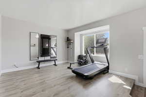 Workout room featuring light wood finished floors and baseboards