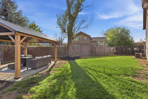 Fenced backyard with outdoor seating, a patio area, and a gazebo