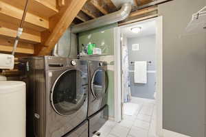 Laundry area featuring separate washer and dryer and light tile patterned floors