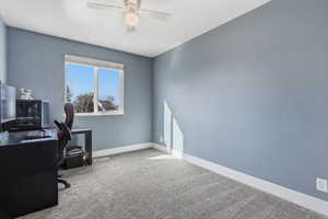 Home office featuring light carpet and a ceiling fan