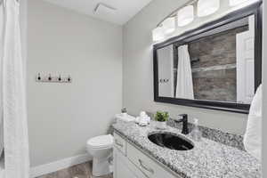 Full bathroom featuring vanity, light wood-style floors, and a shower with curtain