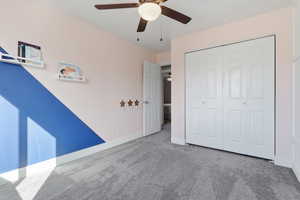 Unfurnished bedroom with carpet flooring, a ceiling fan, and a closet