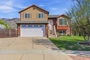 Split level home with driveway, brick siding, a garage, and a shingled roof