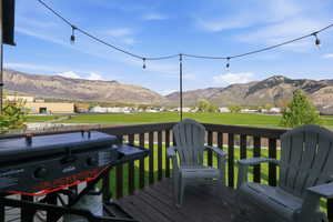 Wooden deck featuring a mountain view, a yard, and area for grilling