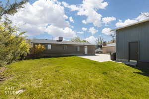 Back of house featuring a yard, a patio area, and brick built home