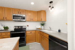 Kitchen featuring stainless steel appliances,  pendant lighting, , light wood-type flooring, and wood finish cabinetry