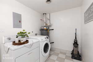 Laundry area with light flooring, electric panel, secured water heater, and washing machine and clothes dryer