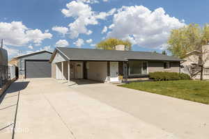 Ranch-style house with roof with shingles, driveway, a carport, and an Large detached garage