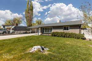 Ranch-style home featuring a carport, brick siding, a shingled roof, and driveway