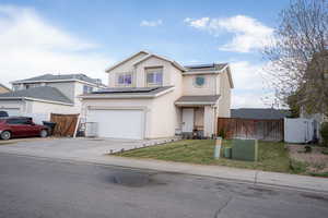 Traditional home with a gate, solar panels, stucco siding, and concrete driveway