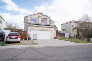 Traditional-style house featuring a gate, roof mounted solar panels, stucco siding, and an attached garage