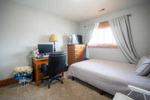 Bedroom with carpet floors and a desk