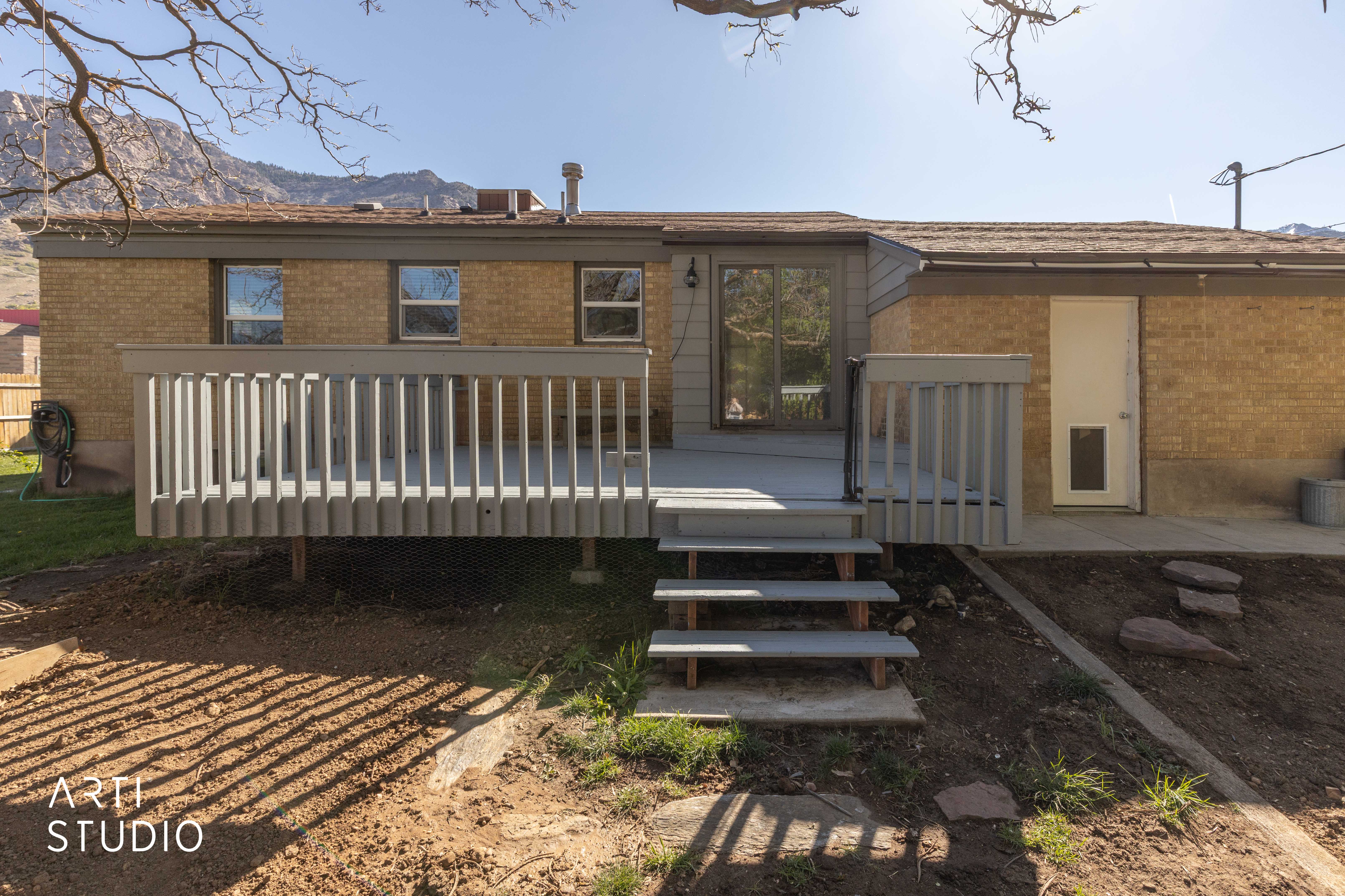Back of house featuring brick siding and a deck with mountain view