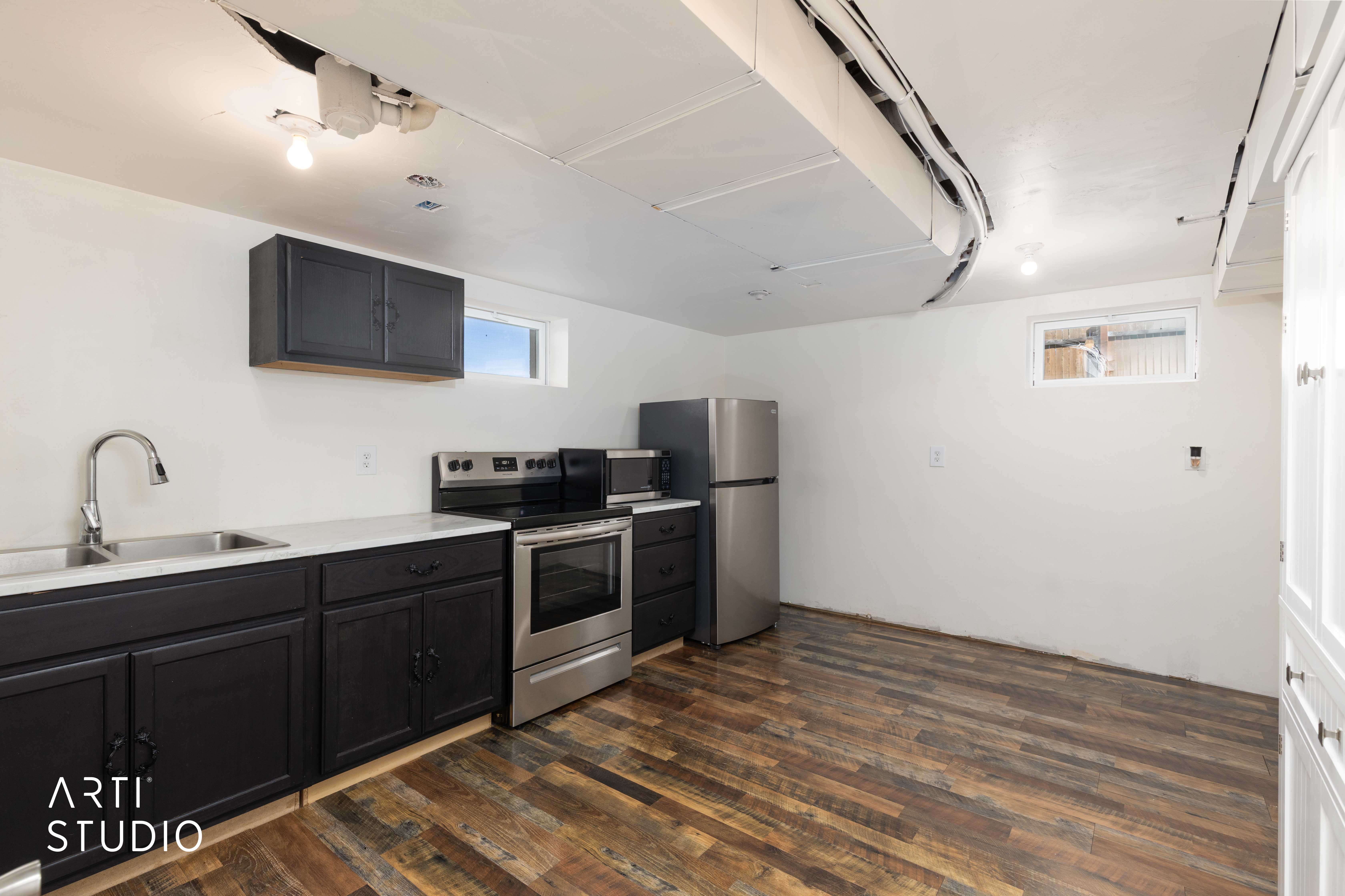 Kitchen with light countertops, stainless steel appliances, dark wood-style floors, and dark cabinets