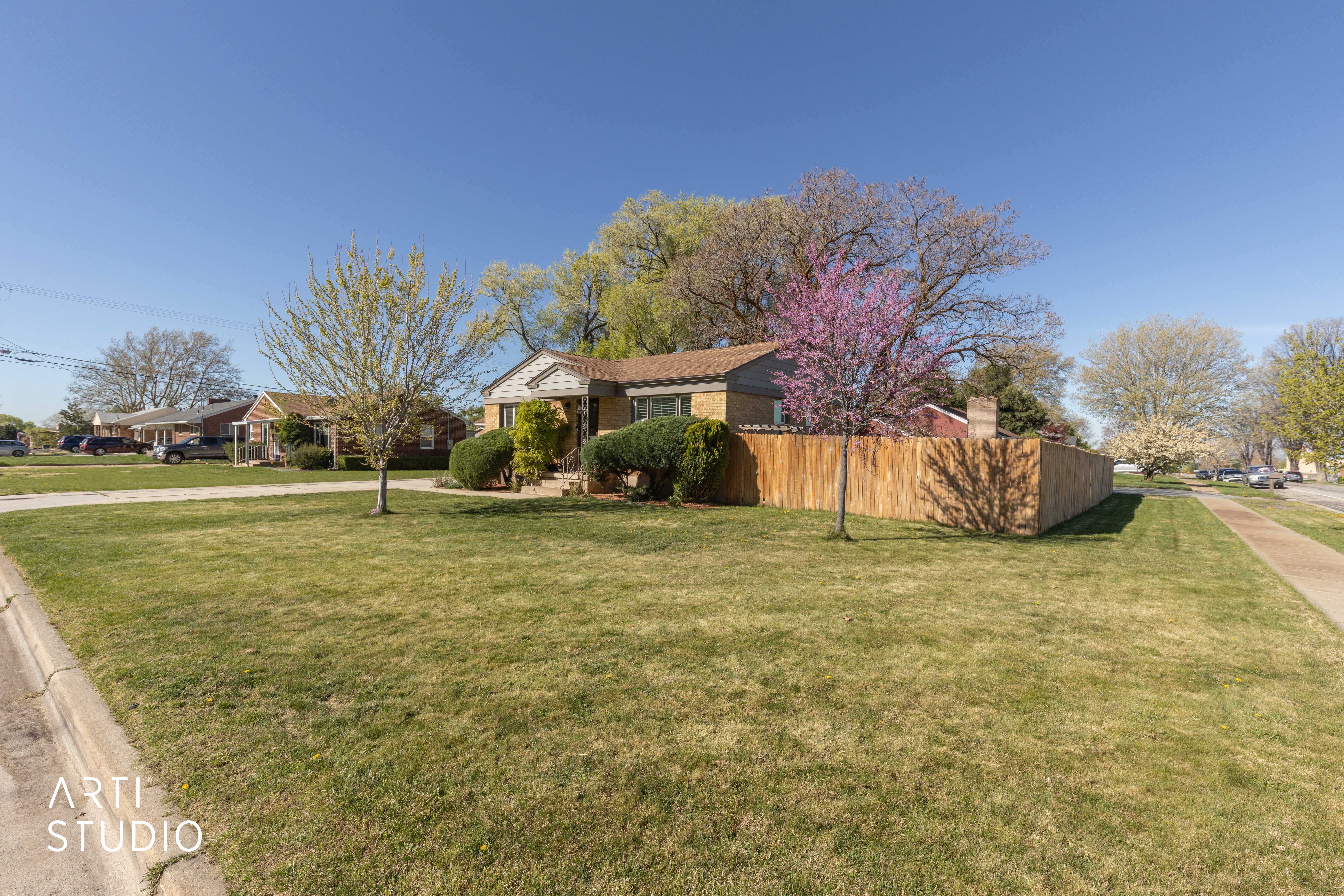 View of front of property showing lawn and blooming tree blossoms