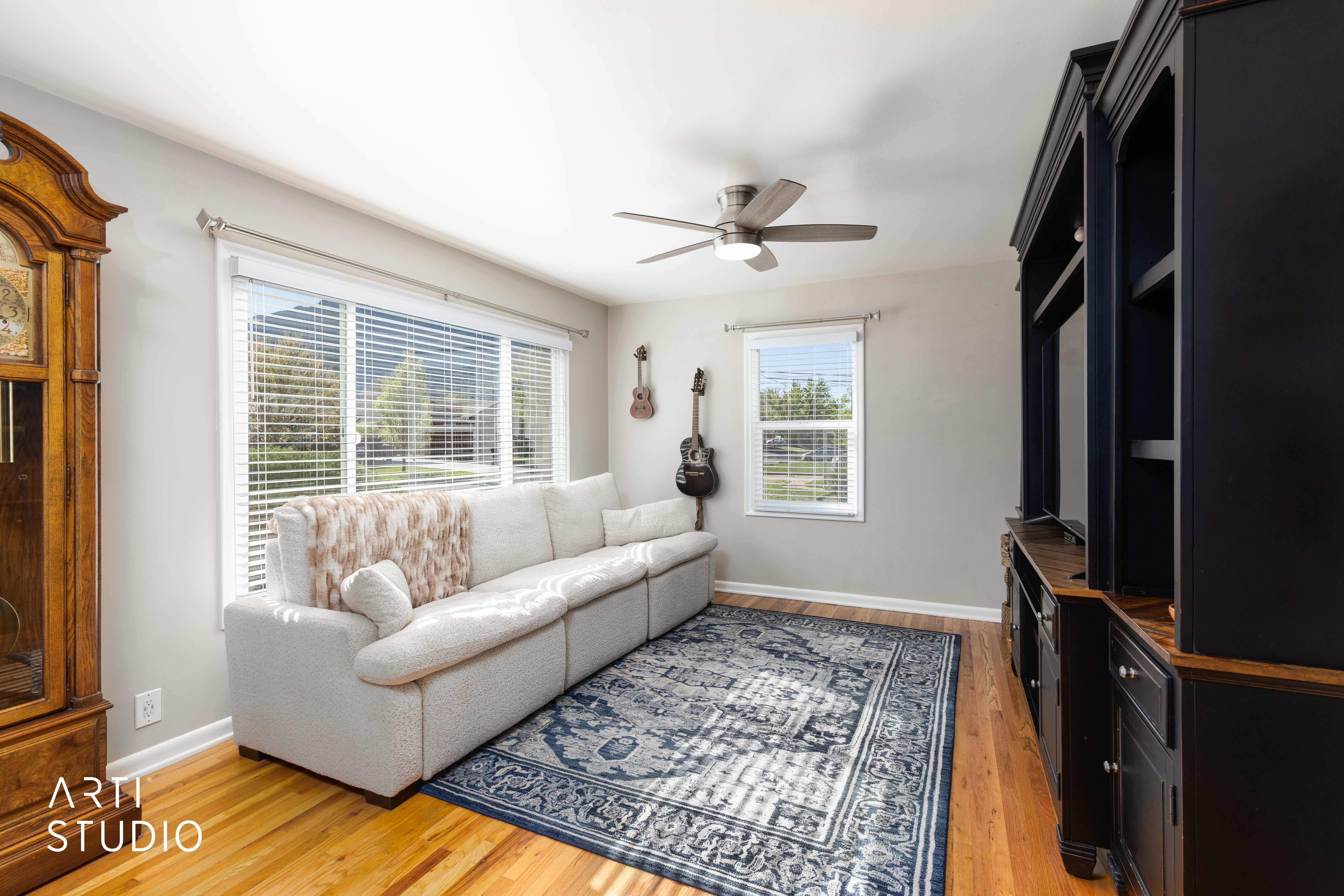 Living room featuring hardwood flooring and morning light through windows.