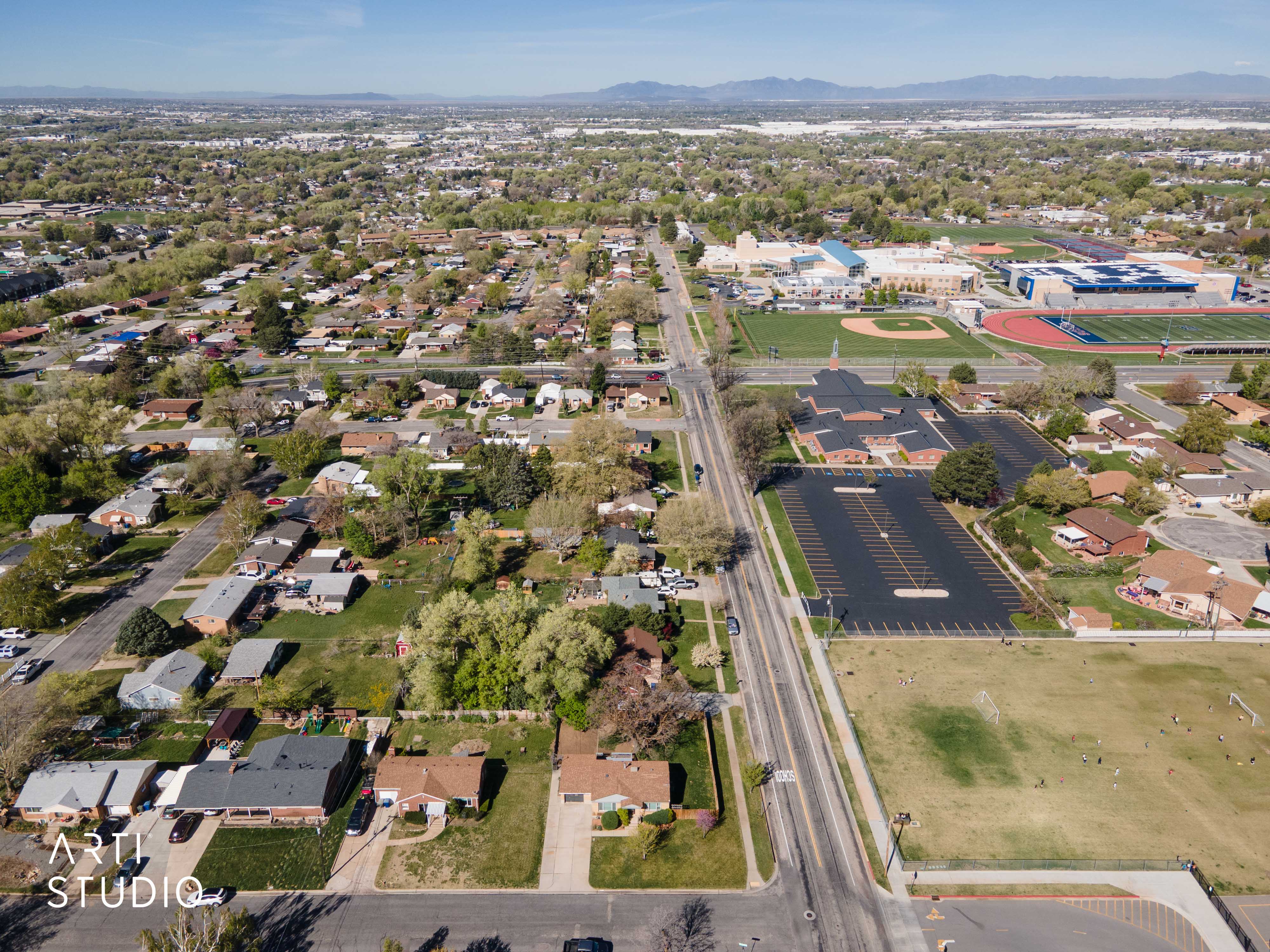 Aerial view of property and surrounding area with a mountain backdrop and nearby suburban area