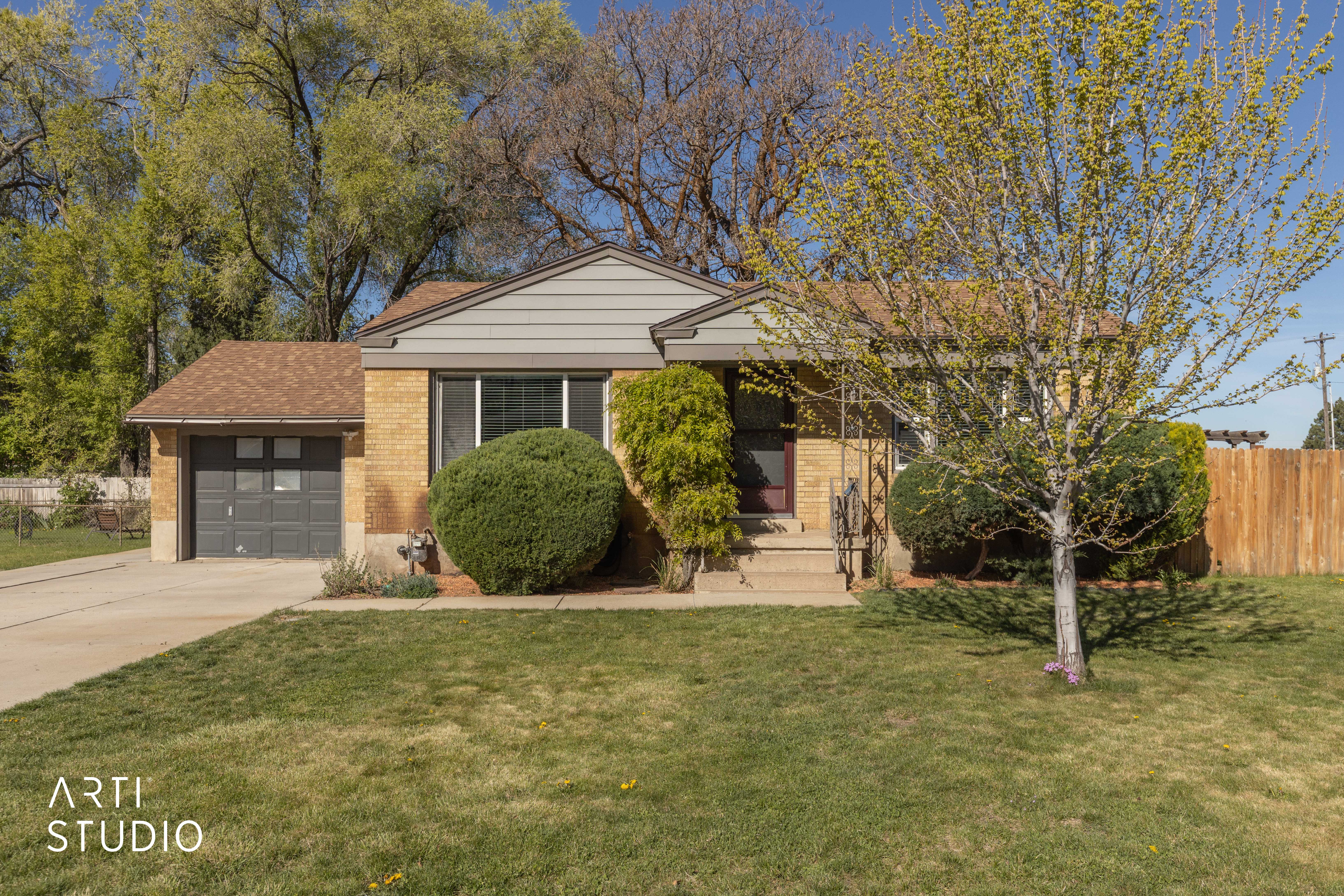 View of front of property with brick siding, an attached garage, and driveway