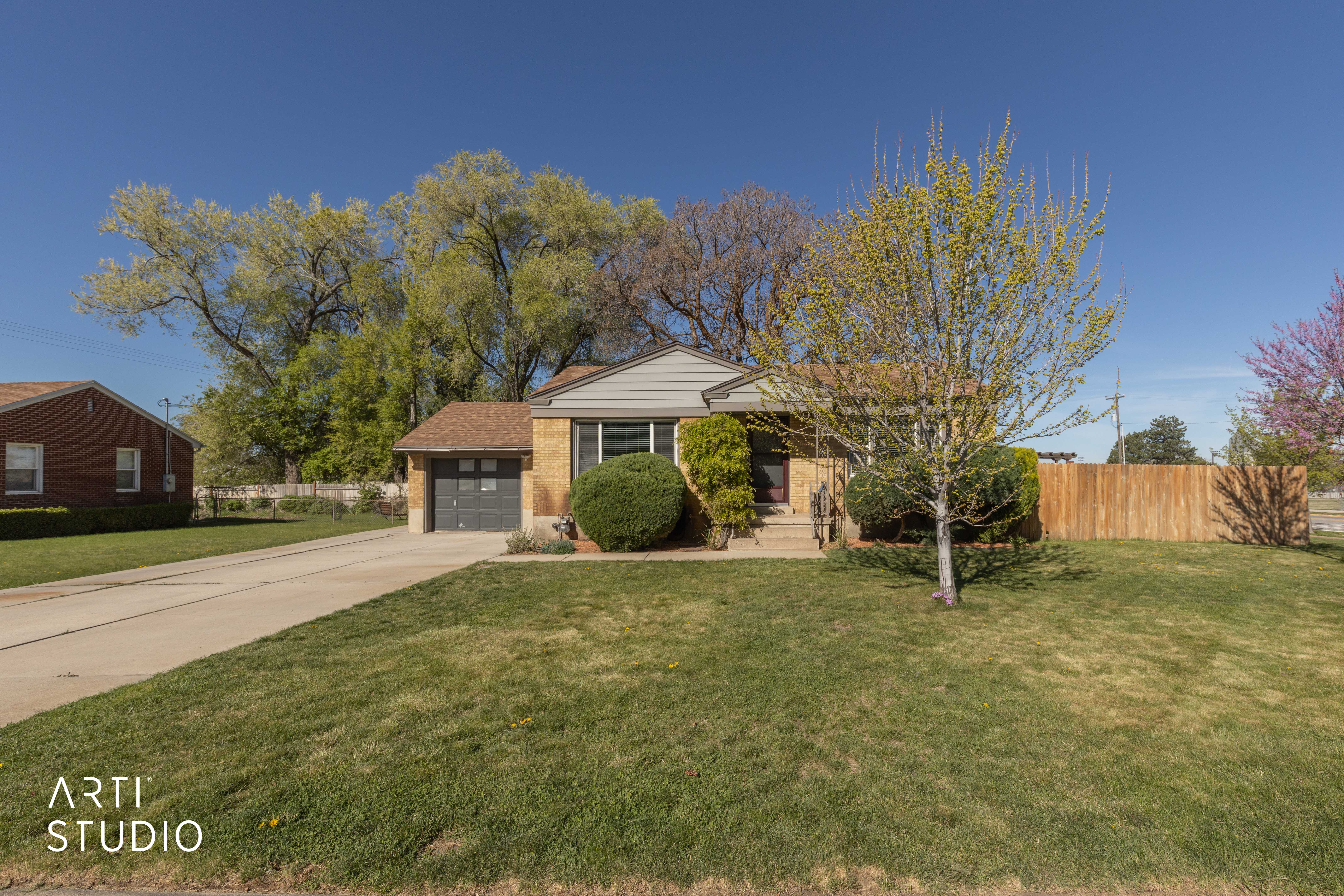 View of front facade featuring driveway, an attached garage, and brick siding