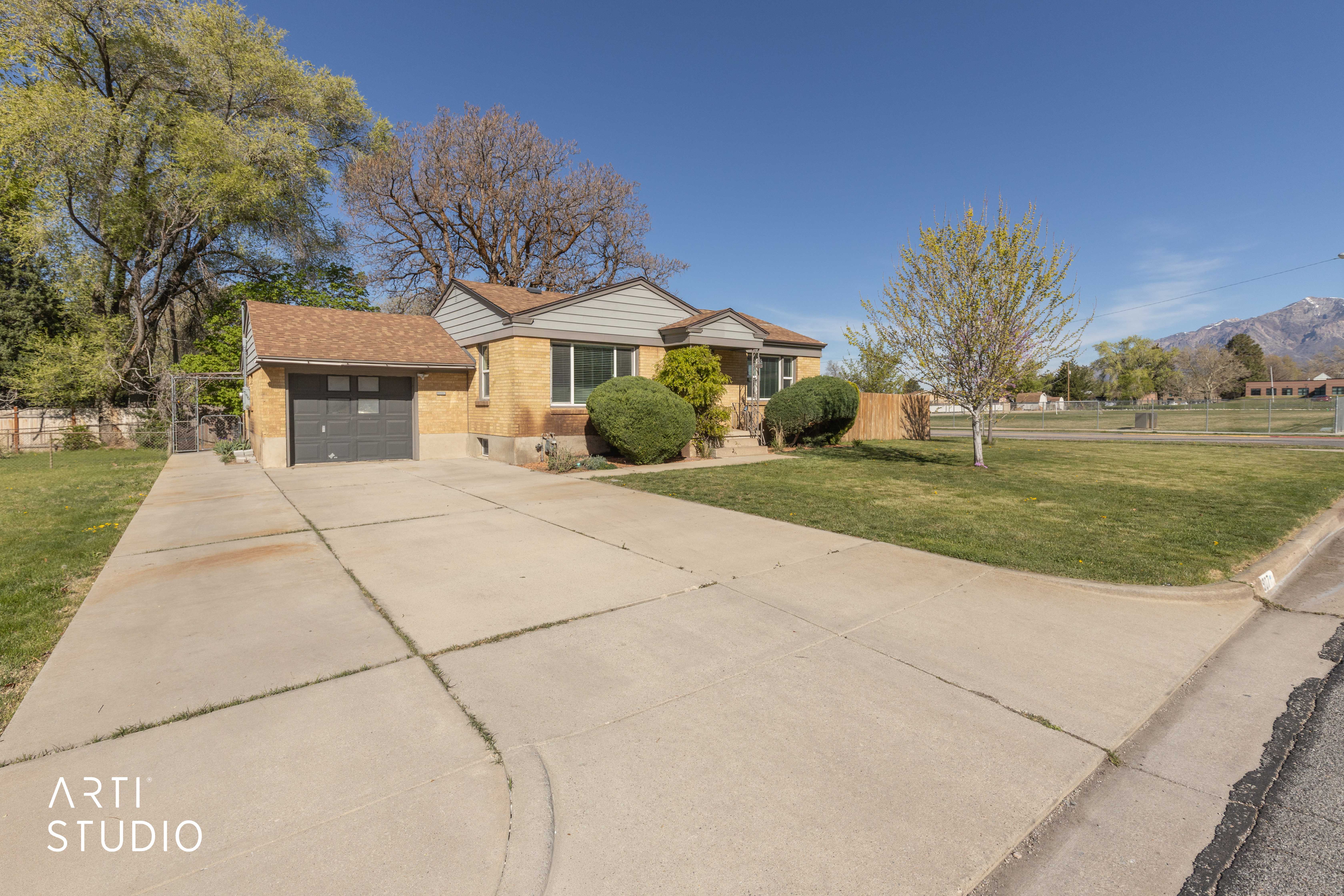 View of front of house featuring driveway, brick siding, an attached garage, and a mountain view