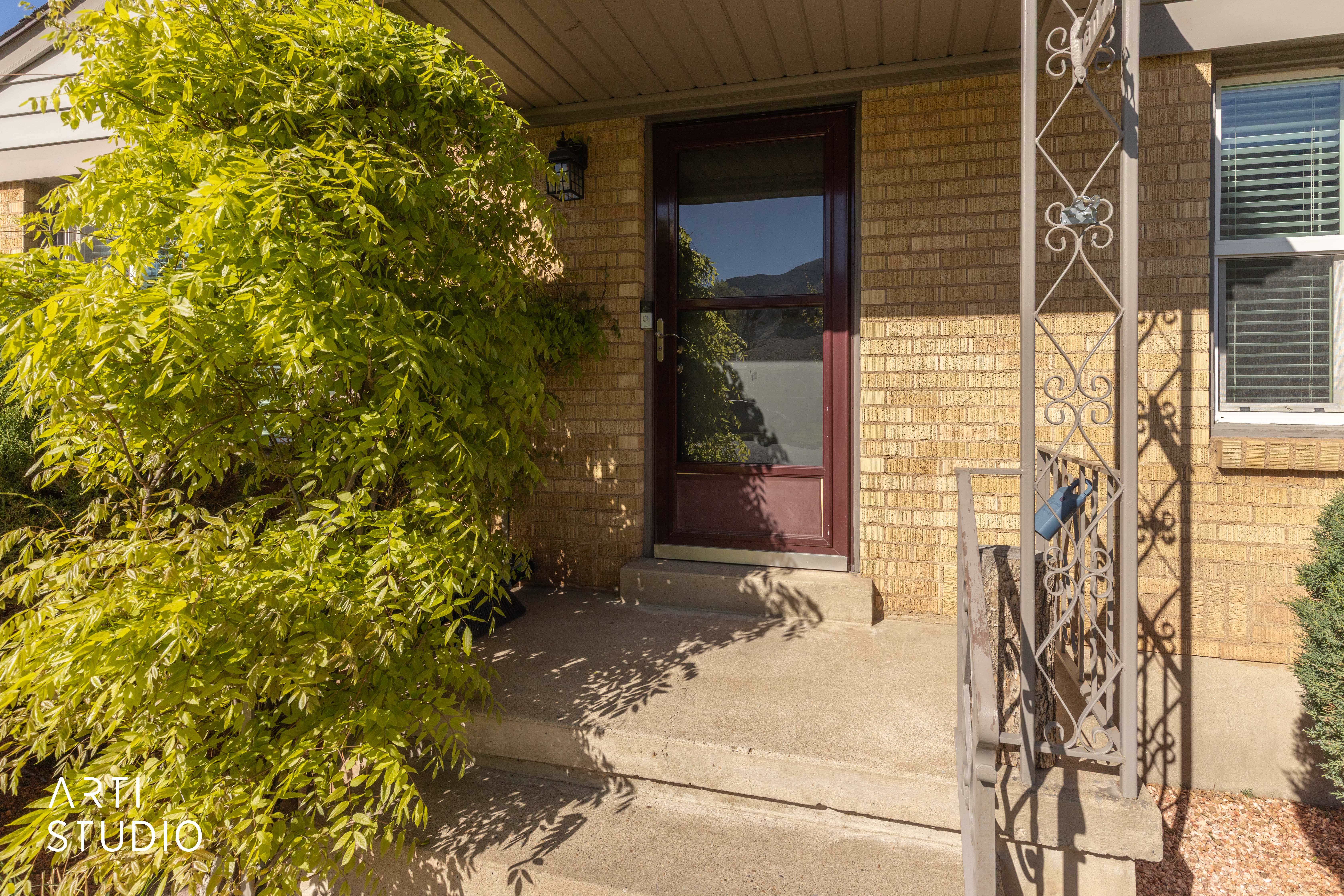 Property entrance featuring brick siding and a porch