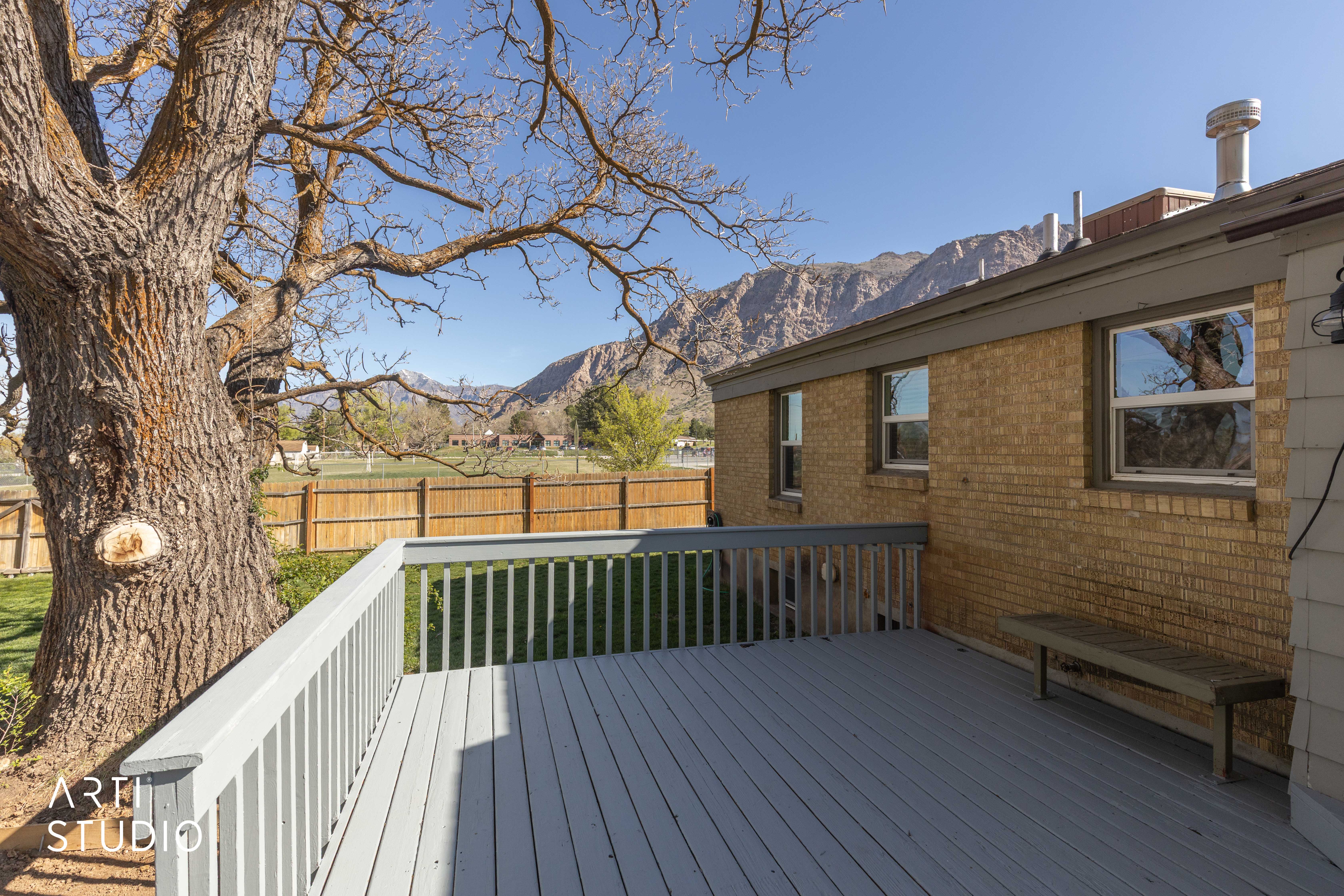 Deck with a fenced backyard and a mountain view