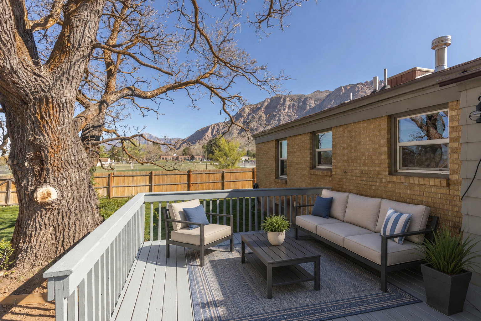 Deck on west side of home featuring railing system, and virtually staged with patio style furniture.