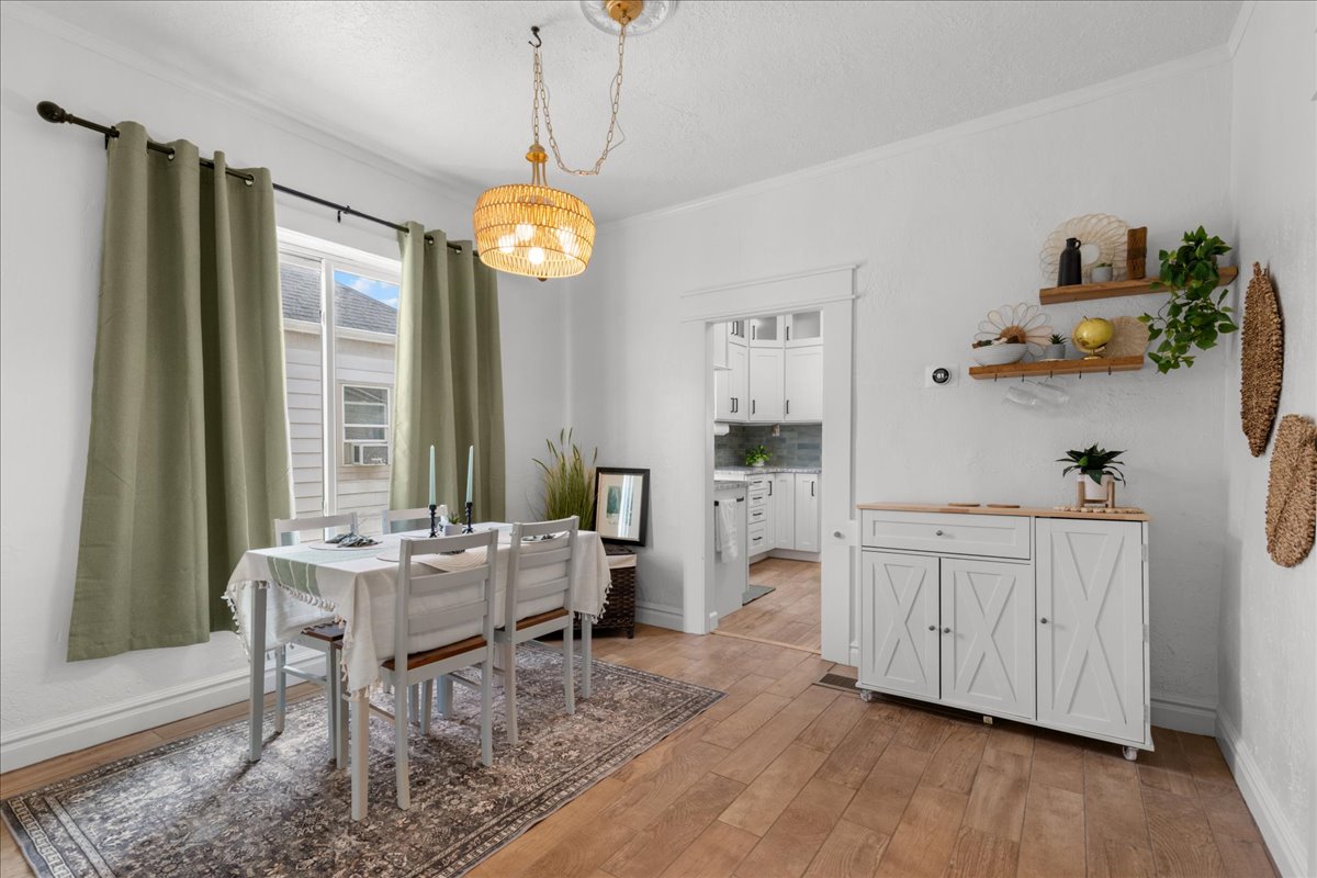 Dining area with light wood-style floors and crown molding
