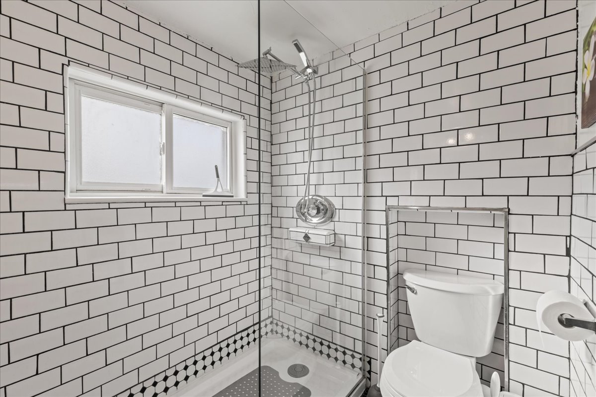 Bathroom with a stall shower and tile walls