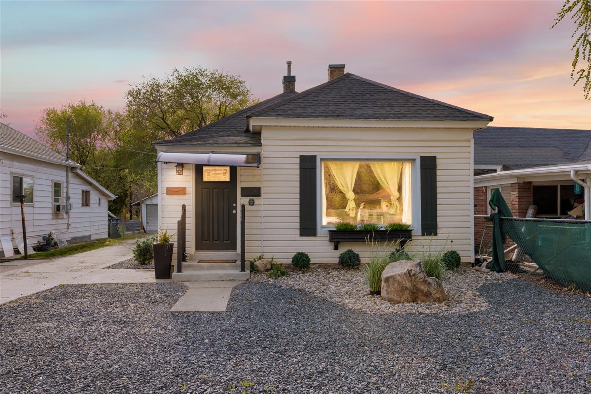 View of front of house featuring a chimney, a shingled roof, and concrete driveway