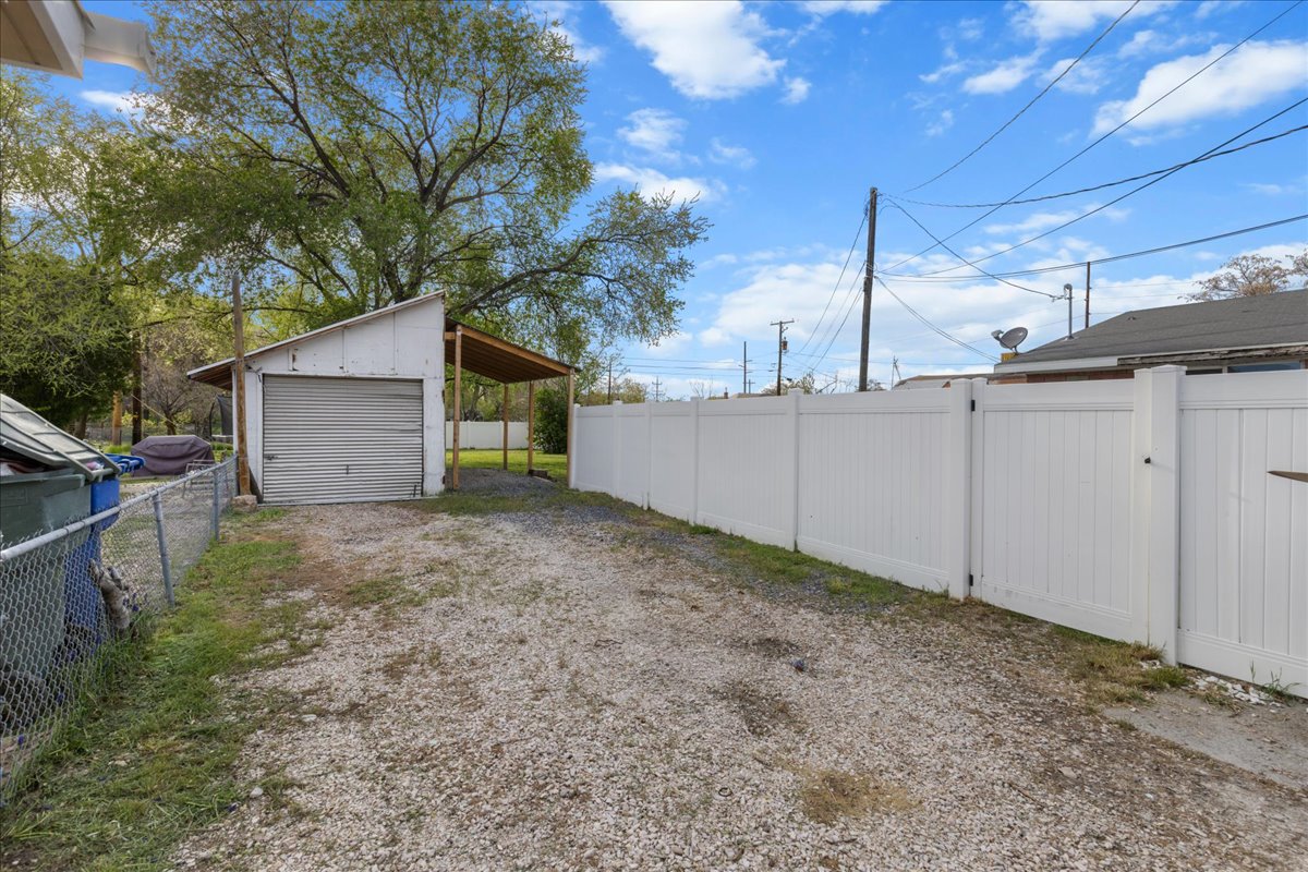 View of yard featuring an outdoor structure, driveway, and a detached garage