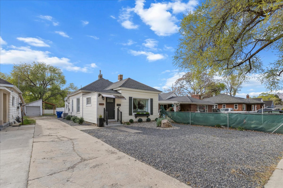 View of front of home with an outdoor structure, a garage, and a chimney