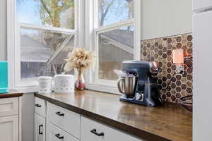 Kitchen view of white cabinet, and decorative backsplash
