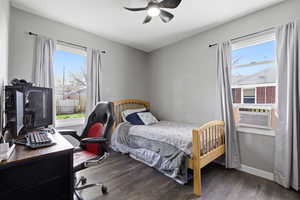 Bedroom featuring a desk, dark wood-style flooring, and a ceiling fan